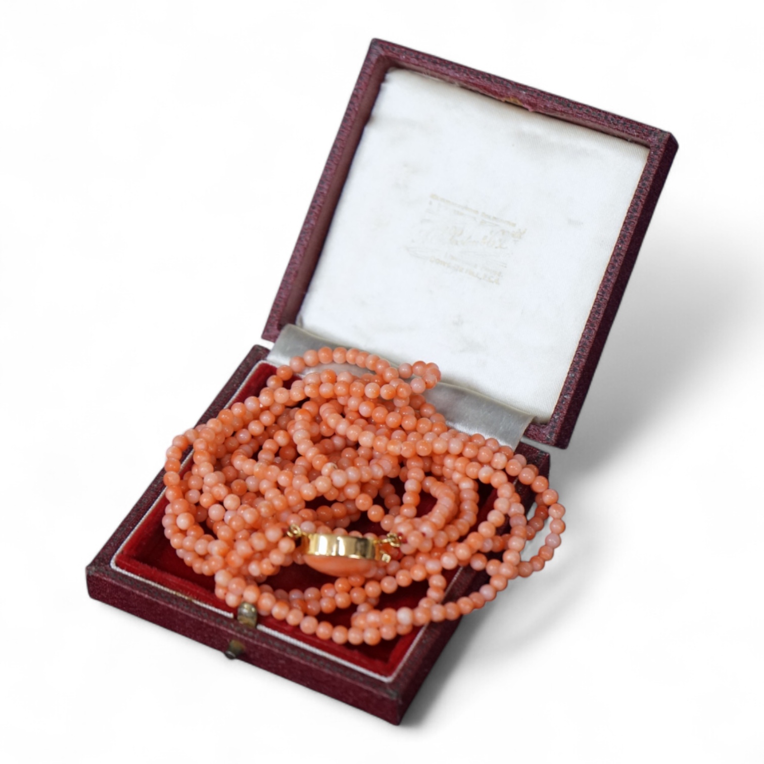 A multi strand coral bead necklace, with cabochon coral set gilt metal clasp, 47cm.